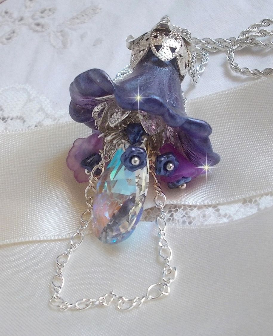 Pendentif Eclat de Cristal monté avec une goutte en Cristal, fleurs en Verre, fleurs lucites dont une plus grande peinte à la main avec paillettes Argentées. Une composition florale