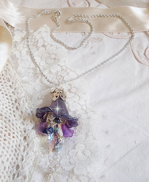 Pendentif Eclat de Cristal mont&eacute; avec une goutte en Cristal, fleurs en Verre, fleurs lucites dont une plus grande peinte &agrave; la main avec paillettes Argent&eacute;es. Une composition florale