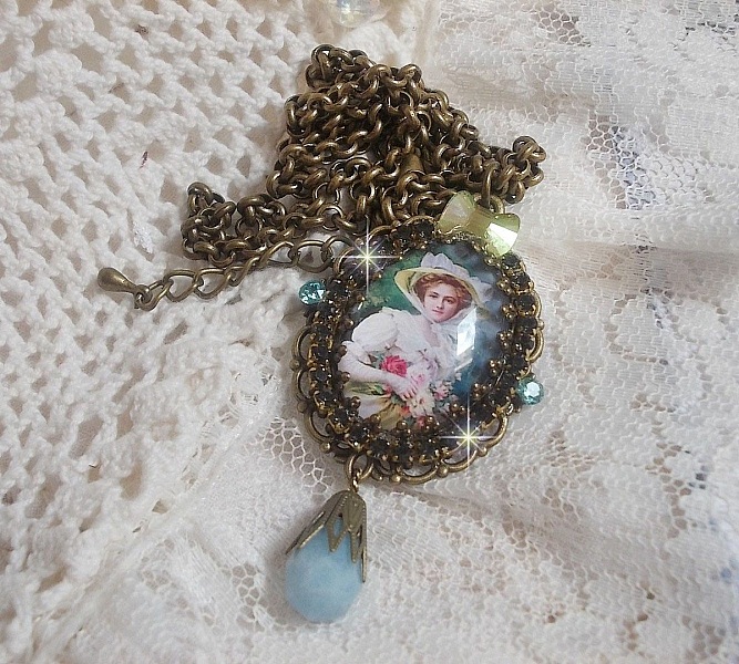 Pendentif Douce Dame cr&eacute;&eacute; avec un cabochon repr&eacute;sentant une femme au chapeau blanc orn&eacute; de cristaux, des accessoires de couleur Bronze et un jade teint&eacute; bleu 