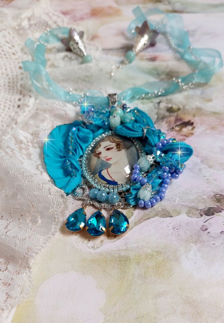 Pendentif Mademoiselle au style rétro avec cabochon d’une femme souriante, orné d’un ruban de soie Bleu, cristaux, perles verre : rocailles et roses, coupelles et chaîne Argent 925/1000