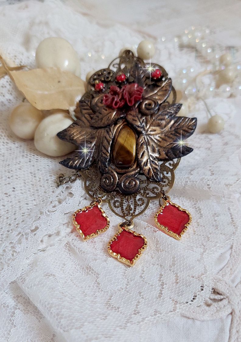 Pendentif Mélodie avec un cabochon Œil de tigre orné de perles en Jade Rouge veiné de Noir sur fleurs 5 pétales et estampes montés sur une chaîne bronze. Les pendants sont en résine époxy Rouge