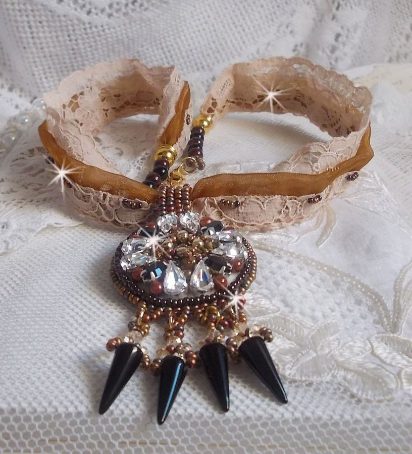 Pendentif Pampilles Amber brodé avec des Cristaux de Swarovski, des facettes Antique, des spikes noires, une estampe dorée filigranée, des rocailles et de la dentelle ancienne