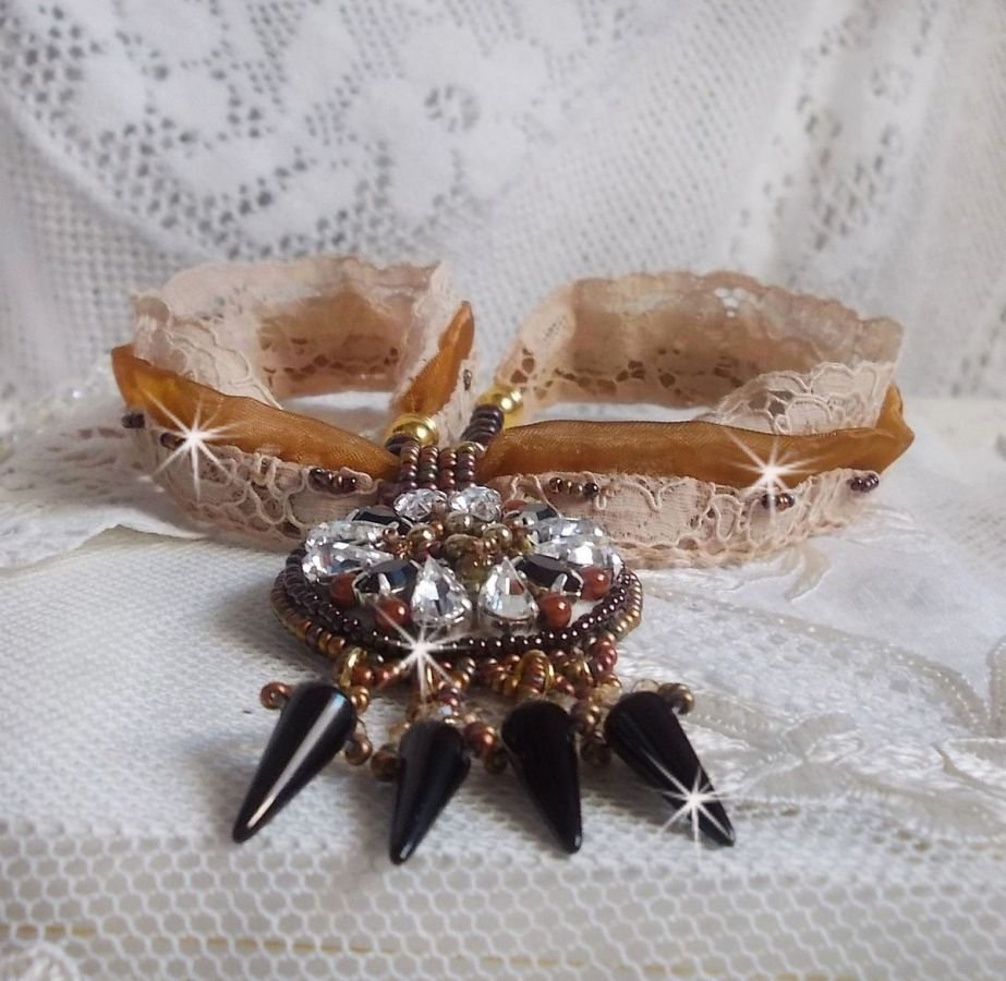 Pendentif Pampilles Amber brodé avec des Cristaux de Swarovski, des facettes Antique, des spikes noires, une estampe dorée filigranée, des rocailles et de la dentelle ancienne