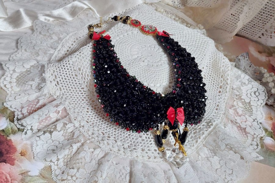 Plastron Nuit d’Etoiles brodé avec toupies, poire facettée en Cristal, perles rondes aplaties, perles potirons, estampes, cabochons, nœud, strass, rondelles avec une chaînette et un fermoir plaqué or