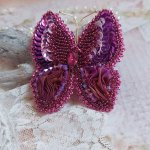 Broche Papillon Violine Fuchsia brodée avec un ruban de soie Fuchsia, Rose et Bordeaux à laquelle s’ajoute une navette sertie, des toupies en Cristal de Swarovski, sequins pailletés et rocailles