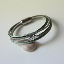 Multi-leather bracelet in shades of beige, pale green and pearly, decorated with a small feather